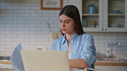 Videocalling girl examining documents talking at zoom meeting on laptop closeup
