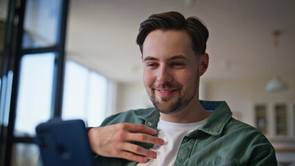 Emotional hipster video calling by phone on home closeup. Positive guy talking