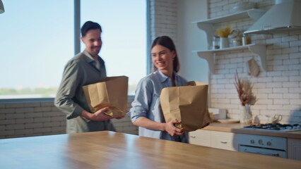 Couple arrived grocery store putting shoppings on kitchen countertop closeup
