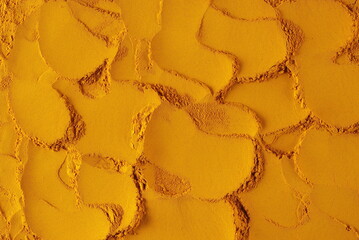 Turmeric powder pile background and texture, top view	
