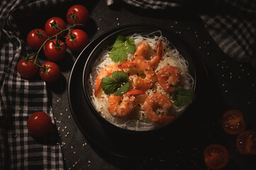 shrimp in a black bowl with cherry tomatoes
