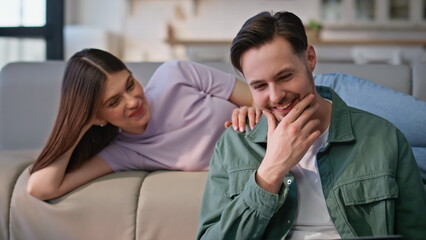 Laughing pair looking laptop together closeup. Couple speaking at apartment