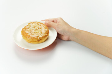 Hands Holding Peanut Butter Donut on White Plate