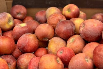 Box filled with fresh natural bio organic red apples placed on counter in local food market