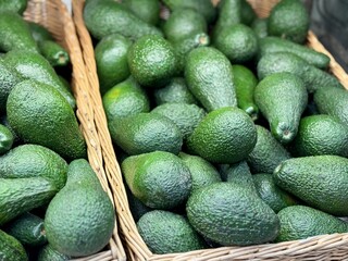 Large rifle green avocados harvested ready to eat are sold on supermarket shelves top view. Healthy eating. Close-up