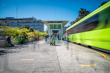 View of the public transport boarding station. Spectrum of people in motion caused by the long...