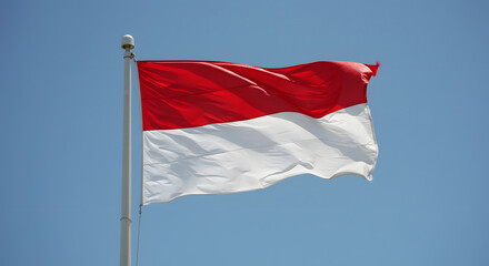 Naklejka premium Indonesian Flag Waving Proudly Under a Clear Blue Sky: A Symbol of National Identity and Unity