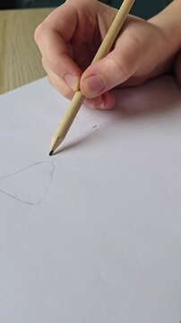 Kid creating artwork with pencil, Close-up of young girl&rsquo;s hands drawing and erasing on paper with pencil and eraser. Vertical footage for educational content, drawing tutorials