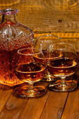 Ballon di cognac con bottiglia su sfondo di legno 