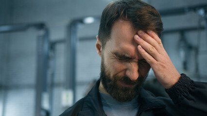 Close up Caucasian ill sick unwell man mechanic technical engineer automotive industry worker working hard at auto car truck service suffer headache feeling bad migraine overworked painful head ache