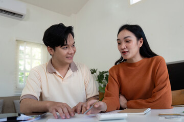Fototapeta premium Couple reviewing expenses and calculating bills together at home, fostering teamwork.