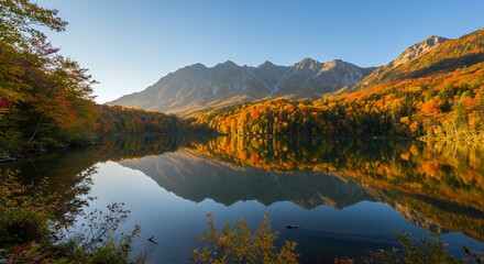 Obraz premium Still Lake Reflecting Autumn Trees and Mountains on Sunny Day