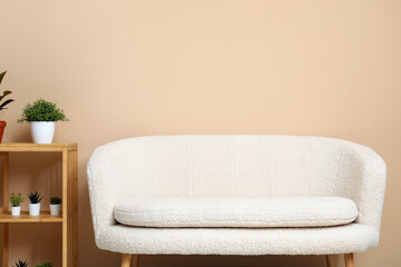 Modern living room interior with cozy white sofa, shelving unit and plants