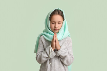 Praying Muslim girl on light background