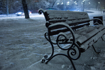 winter landscape night view bench with forged details covered with snow
