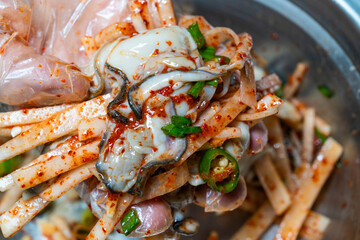 raw oysters seasoned with spicy sauces, vegetables and other ingredients