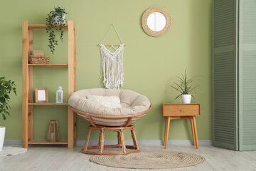 Armchair, shelving unit, mirror and bedside table in interior of living room