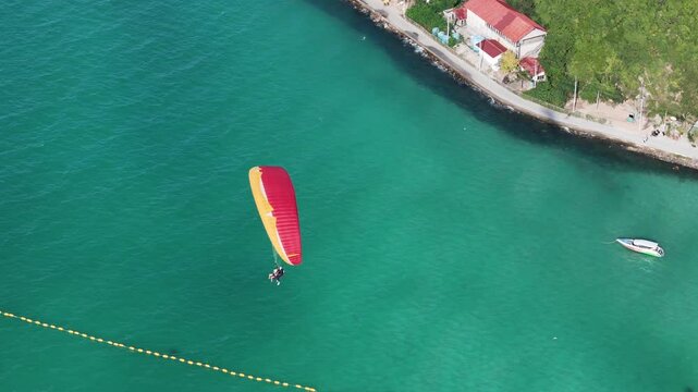 Paragliding in Thailand with blue sea. Two man paragliding high up in the sky. tourist attraction. Paraglider flies above the mountains in a bright sunny day