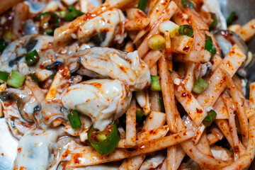 raw oysters seasoned with spicy sauces, vegetables and other ingredients