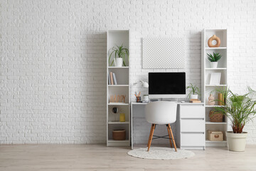 Interior of office with workplace, plants and shelf units