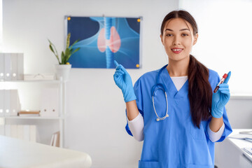 Female Asian endocrinologist with blood sample for TSH test in clinic