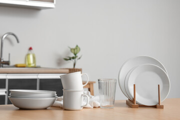 Clean dishes and napkin on wooden table in kitchen