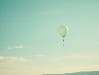 Fototapeta premium Soaring Aspirations: A solitary balloon ascends gracefully, a poignant emblem of hope and liberation, set against an expansive backdrop of sky.