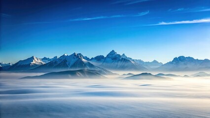 Obraz premium Serene Winter Landscape Snow-capped Mountain Range Under a Clear Blue Sky, Misty Valley Below