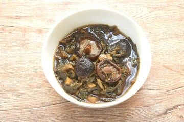 boiled chop dry salty pickled cabbage with black mushroom and slice pork belly in Chinese herb brown soup on bowl