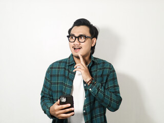 Adult Asian man holding his mobile phone with happy expression isolated on white background