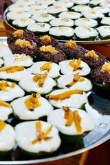 Khanom Tako (a Thai dessert made from glutinous rice flour and coconut cream, served in a pandan leaf or banana leaf casing) at Khlong Lat Mayom, a floating market in Taling Chan, Bangkok, Thailand