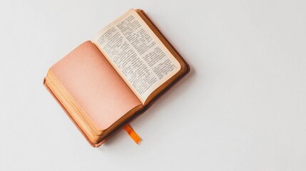 Obraz premium Open Book with Blank Pages and Orange Bookmark on a White Surface