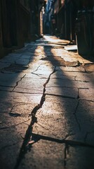 Narrow Street with Cracked Pavement and Warm Sunlight Reflection