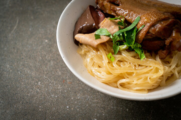 dried noodles with braised duck in white bowl