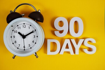 90 Days alphabet letters with alarm clock on yellow background