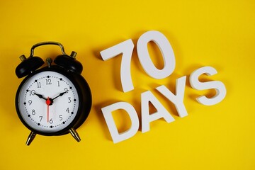 70 Days alphabet letters with alarm clock on yellow background