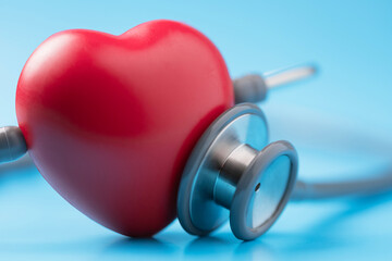 Red heart shape exercise ball with doctor physician's stethoscope on blue background, hospital life insurance concept, world heart health day. doctor day