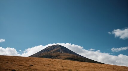 there is a mountain with a cloud in the sky above it