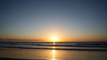 Naklejka premium arafed view of a beach with a sunset and a person on the beach