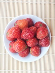 Strawberries in a small white plate. Top of view. 
