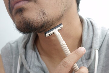 Close-Up of Man Shaving Beard with Razor for Personal Grooming