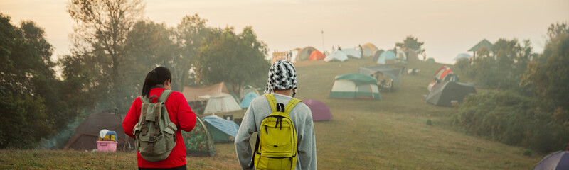 Couple traveler with backpack hiking outdoor travel lifestyle and adventure concept. cap backpack and join of tourist for green mountain tour, beauty of nature and expansive sky people of tourism