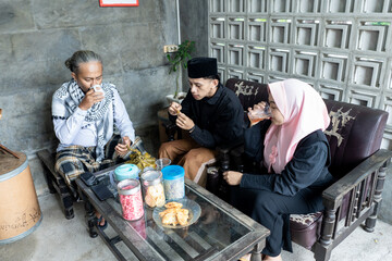Lebaran homecoming in his hometown greet each other apologizing with friends during the Eid. adult man receives young man's guest during Eid. entertaining guests 