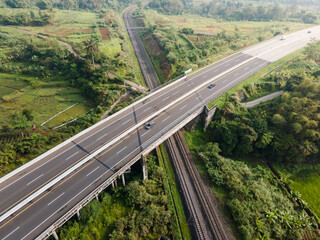 Aerial View of a Highway Over a Railway Track Near Rural Farmlands