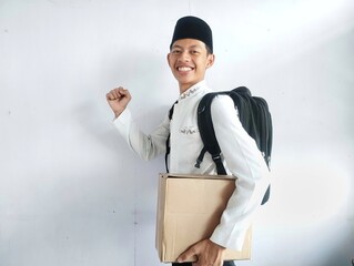 Muslim man carrying cardboard box and black bag with happy face