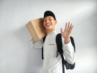 Muslim man carrying cardboard box and black bag with happy face