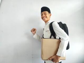 Muslim man carrying cardboard box and black bag with happy face