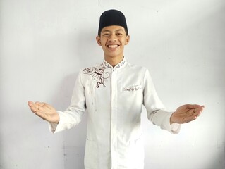 Moslem Asian man smiling at the camera with arms open doing welcoming gesture