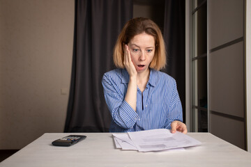 Utility bill shock, woman stressed by high gas and electricity costs, checking a document with a...