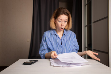 Utility bill shock, woman stressed by high gas and electricity costs, struggling with financial...